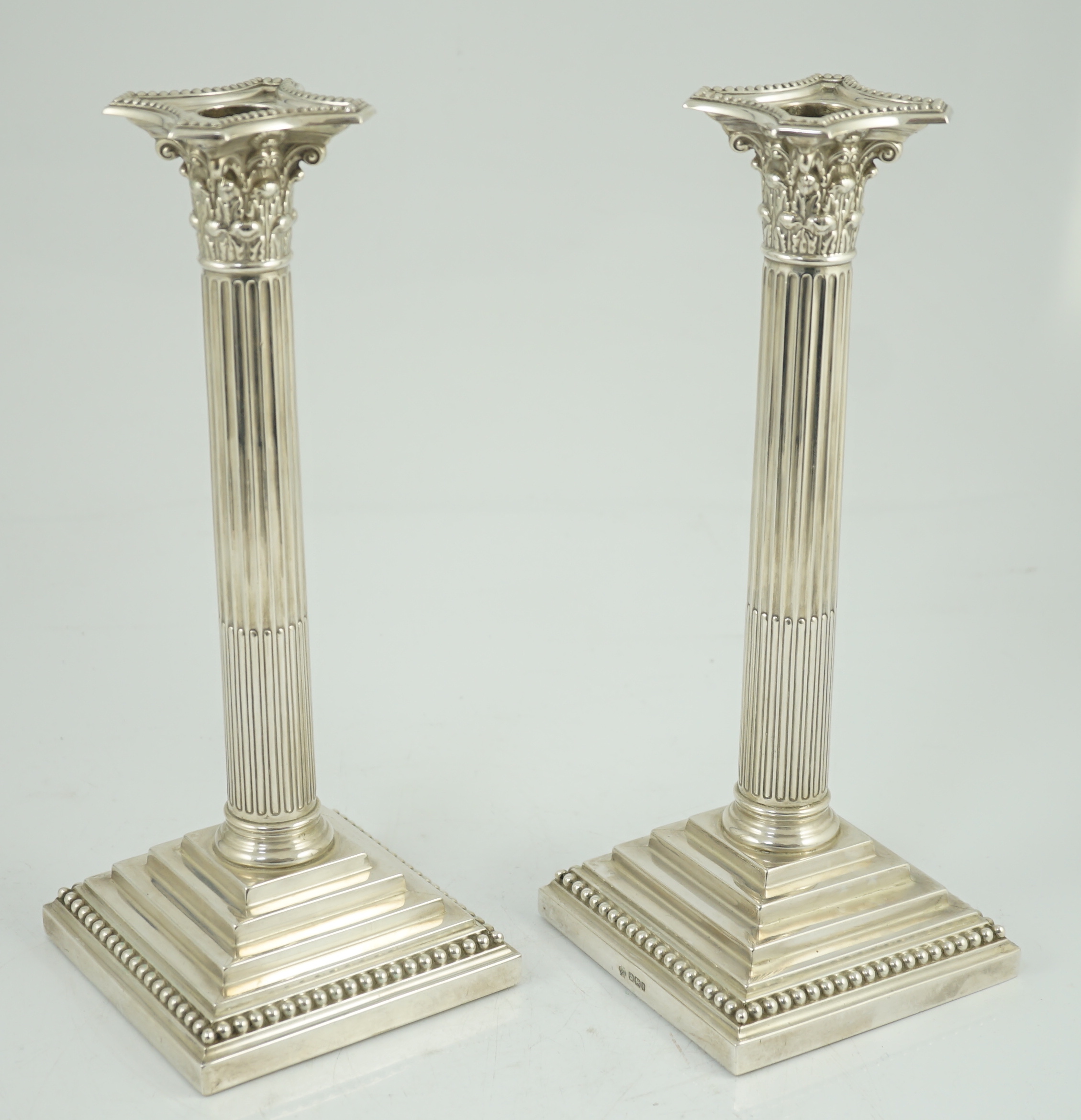 A pair of late Victorian silver Corinthian column candlesticks, by William Hutton & Sons